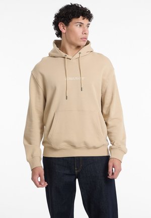 Beige Baumwoll-Hoodie mit einer Fronttasche, Kapuze mit Kordelzug und gesticktem "GUESS JEANS"-Schriftzug. Gerippte Bündchen und Saum, entspannte Passform.