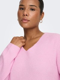 Pink ribbed sweater with a V-neckline and long sleeves. The texture appears soft, with a close-up view of fabric details and minor fuzziness.