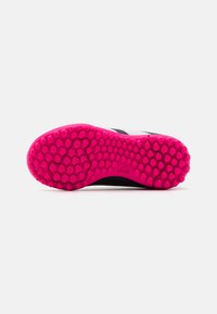 Suela de zapatilla deportiva en blanco y negro que presenta una superficie texturada y una suela exterior de color rosa vívido con patrones hexagonales y un logo de la marca.