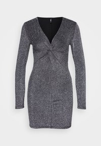 Långärmad, kroppsnära klänning i svart och silverglittrande tyg. Har en V-ringning och en tvistad framdetailj. Slät textur, knälång.