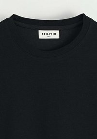 T-shirt en coton noir avec un col rond, arborant une étiquette cousue indiquant "FRILIVIN" et la taille "S". Texture lisse, design décontracté.