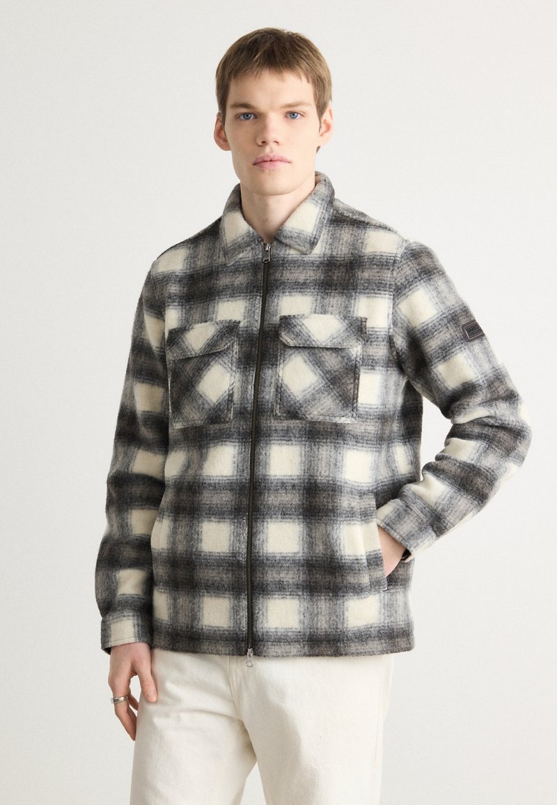 Men's plaid jacket made of wool blend fabric, featuring gray and white check pattern, zip closure, and two front pockets with flaps.