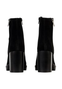 Botas de tobillo de ante negro con punta cuadrada, tacón de madera grueso y cierre de cremallera trasero. Textura suave sin patrones o acentos visibles.