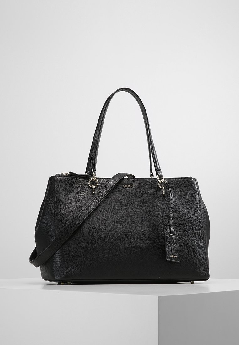 Svart läderhandväska med texturerad yta, dubbla handtag upptill och avtagbar axelrem. Utrustad med guldfärgad hårdvara och en etikett som accent.