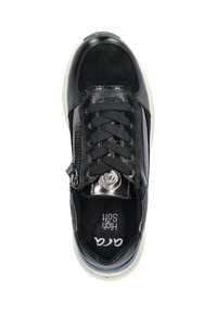 Baskets de sport noires avec un mélange de matériaux lisses et texturés, fermeture à lacets et zip sur le côté, semelle intérieure rembourrée et semelle en caoutchouc blanche.