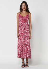 Rotes Maxikleid mit weißem Musterdesign, ausgestattet mit dünnen Tr�ägern und einem gestuften Saum. Hergestellt aus leichtem Stoff, bietet es eine lässige Passform.