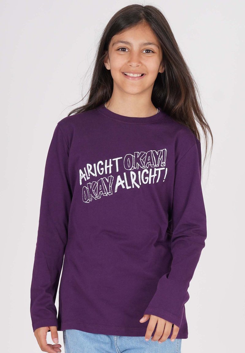 Lila Langarm-T-Shirt aus Baumwolle mit fettem weißen Aufdruck: "ALRIGHT OKAY! OKAY ALRIGHT!" auf der Vorderseite, lockere Passform mit Rundhalsausschnitt.