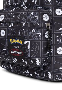 Zaino in tessuto nero con motivi bianchi di personaggi Pokémon, dotato di doppi loghi per Pokémon ed Eastpak, e una tasca anteriore con zip.