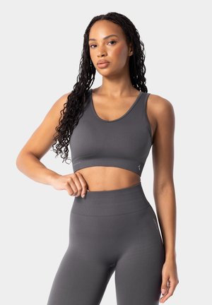 Grå idrotts crop top med rundad hals och ribbad kant, matchad med högmidjade leggings som har en slät yta och minimal branding.
