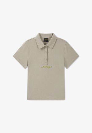 Beige lyhythihainen poolopaita, jossa on kolme nappia ja pieni kirjailtu logo nappilistauksen alla keskellä.