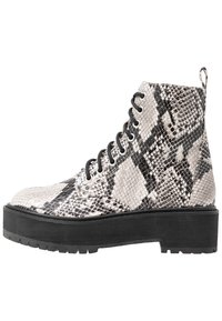 Botín con cordones en patrón de piel de serpiente en blanco y negro y suela gruesa negra.