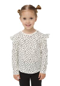 Długo rękawowa koszula dla dzieci, biała z rozsianymi czarnymi wzorami serc, z falbaniastymi rękawami i okrągłym dekoltem.