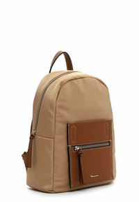 Sac à dos en nylon beige avec une poche avant en cuir marron. Dispose de fermetures éclair en métal argenté et de coutures contrastées. Forme arrondie avec une poignée supérieure.