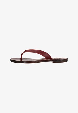 Sandale en cuir rouge avec une fine lanière, semelle plate et détails cousus le long des bords. Design minimaliste avec une finition lisse.
