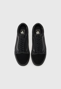 Black sneakers featuring a canvas upper with white stitching details, flat laces, padded collar, round toe, and a rubber sole.