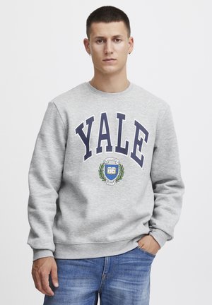 Grijze sweatshirt met "Yale" in vette marineblauwe letters, met een wapenontwerp. Lange mouwen met ribgebreide manchetten en een ronde halslijn.