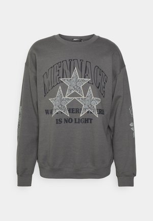 Sweat-shirt gris foncé avec trois étoiles à motifs et le texte "MENNACE" et "IS NO LIGHT" sur le devant.