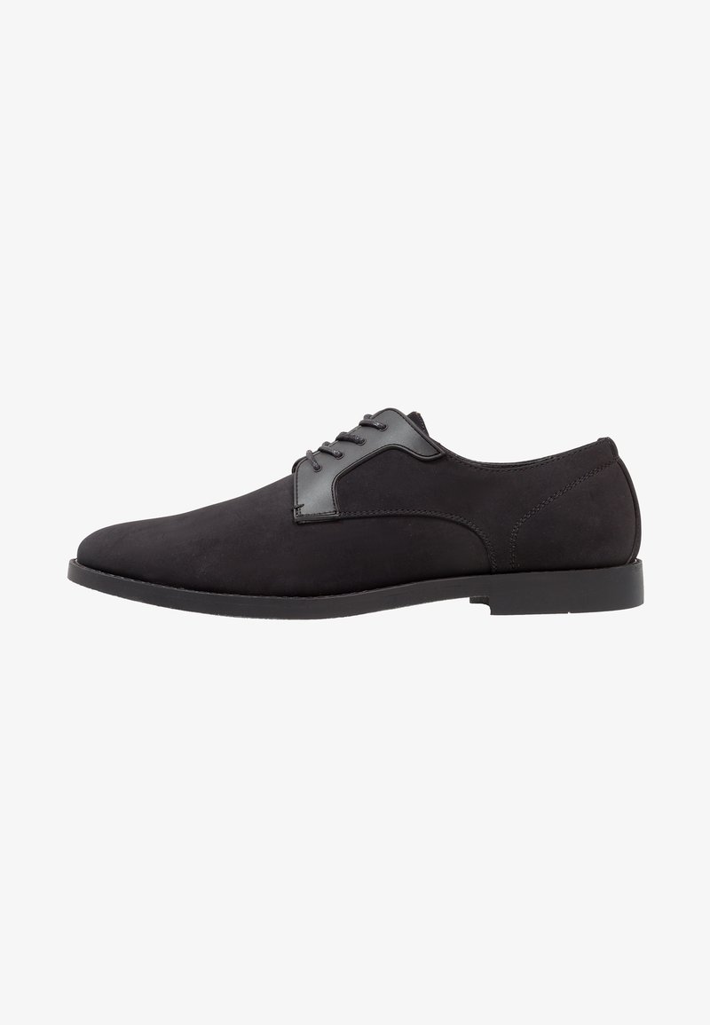 Chaussure formelle noire pour homme à lacets, finition mate et lisse, talon bas et bout arrondi, montrée de profil sur fond blanc.