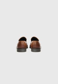 Zapatos de cuero marrón con un acabado suave, tacón curvado y detalles perforados en la parte trasera. Suela de goma negra para mayor tracción.