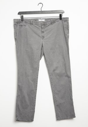 Pantalones de algodón grises colgados en una percha de plástico negra. Cuentan con un bolsillo y un cierre de botón, con una pierna entallada y una textura suave.