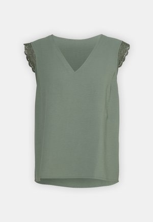 Oliven grønn ermeløs topp med v-hals og delikate blonder detaljer på skuldrene. Myk tekstur med en avslappet passform.