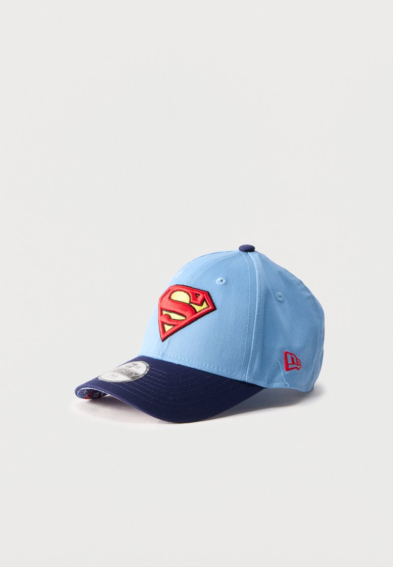 Ανοιχτό μπλε και ναυτικό μπλουζάκι με κόκκινο και κίτρινο λογότυπο Superman στο μπροστινό μέρος και κόκκινο λογότυπο New Era στο πλάι, τοποθετημένο σε λευκό φόντο.