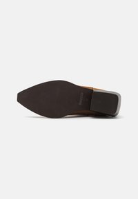 Semelle en cuir brun avec une forme pointue, surface texturée et un léger talon. Marque "BIANCO" visible au bas.