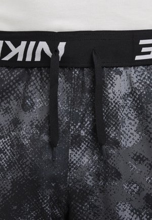 Shorts noirs à motif avec un design texturé gris, dotés d'un waistband élastique noir avec des inscriptions blanches et des cordons de serrage ajustables.