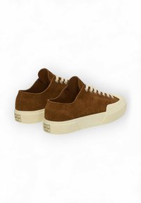 Braune Wildledersneaker mit cremefarbenen Schnürsenkeln, einer strukturierten Gummisohle und einem flachen Design, das ein Markenlogo auf der Ferse aufweist.
