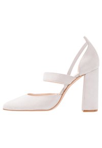 Vit mocka högklackad sko med spetsig tå, justerbar ankelsnär och kraftig klack. Enkel design med jämn textur.