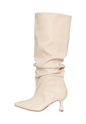 Kremowe, skórzane, luźne kozaki za kolano z wąskim noskiem i smukłym, średniej wysokości obcasem.