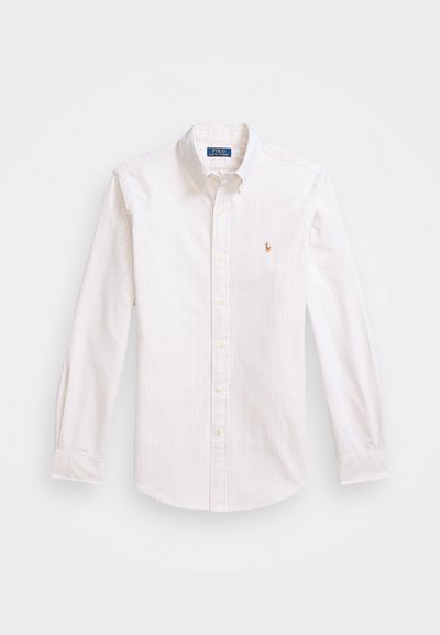 Gaiņu krāsas svītrainā krekls ar garām piedurknēm, ar pogām kaklā un nelielu izšūtu logo. Kokvilnas audums ar gludu tekstūru.