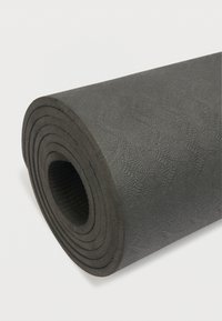Μαύρο στρώμα γιόγκα τυλιγμένο με υφή στην επιφάνεια και στρογγυλεμένες άκρες, εμφανίζοντας ομόκεντρους κύκλους κατά μήκος του ρολού. Λείο, ανθεκτικό υλικό.