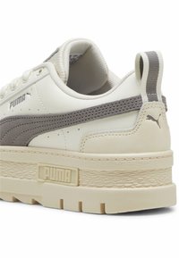 Vita lädersneakers med gråmocka detaljer, tjock krämfärgad gummisula, strukturerad överdel och PUMA-logotyp på sidan samt häftslips.