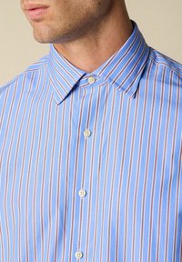 Blauw-wit gestreepte shirt met een klassieke kraag en knoopsluitingen, gemaakt van lichtgewicht stof met een subtiele textuur.