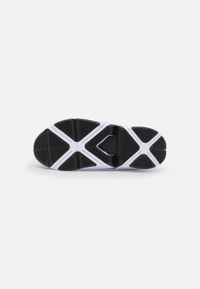 Suela de zapatilla atlética en blanco y negro, con un patrón texturizado y acentos triangulares, y un logo en el centro.