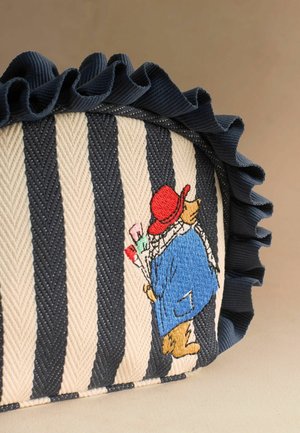 Stribet stofpose med marineblå flæsekant og broderet bjørn iført rød hat og blå frakke, der bærer pensler.