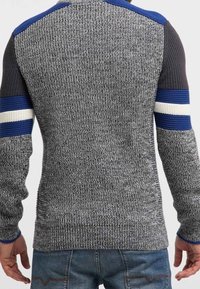 Pull gris en maille avec accents bleus et noirs. Présente des rayures texturées sur les manches et des patches d'épaule lisses, combinant des matériaux variés.