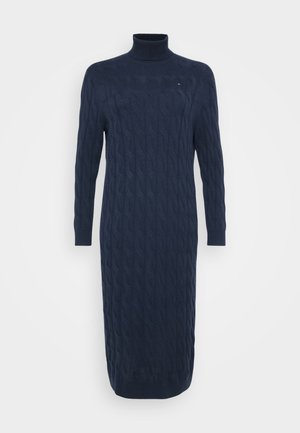 Abito lungo in maglia blu navy con colletto alto e motivo testurizzato, esposto su uno sfondo bianco puro.