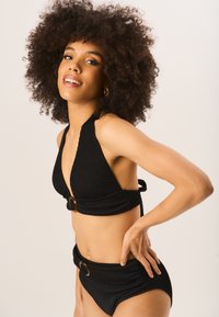 Black ribbed bikini set featuring a halter neck top with a front buckle and high-waisted bottoms with similar detailing.