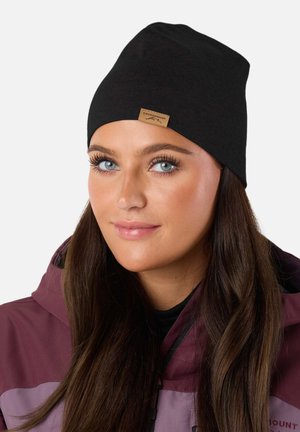 Black knit beanie with a folded cuff and a tan leather label featuring "SWEDEN MOUNTAIN" embossed. Smooth texture; fitted design.