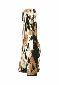 Bottine à talons hauts en fausse fourrure tachetée marron et crème, avec une fermeture éclair et une semelle épaisse noire.