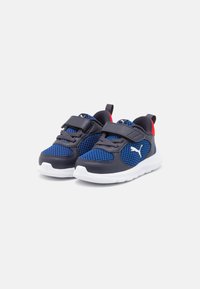 Chaussures de sport bleu et gris avec tige en mesh, sangles réglables et semelle blanche ; elles présentent des accents rouges et le logo Puma sur le côté.