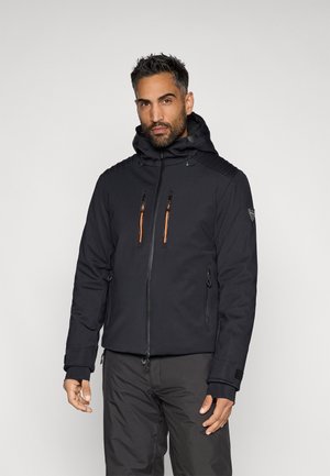 Čierna zateplená bunda s kapucňou, ktorá má oranžové zipsové detaily a textúrované ramená. Obsahuje bočné a predné vrecká.