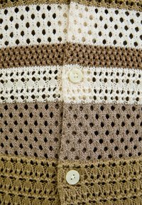 Cardigan all'uncinetto con righe alternate in beige chiaro, marrone chiaro e marrone. Presenta un bottone decorativo e una trama a rete aperta.