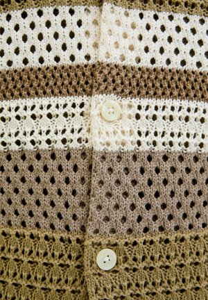 Cárdigan de ganchillo con rayas alternas en beige claro, marrón claro y marrón. Presenta un botón decorativo y una textura de tejido abierto.