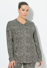 Langärmliges Oberteil in Beige mit schwarzem Leopardenmuster, das ein V-Ausschnitt-Design aufweist. Der Stoff hat eine glatte Textur und eine lockere Passform.