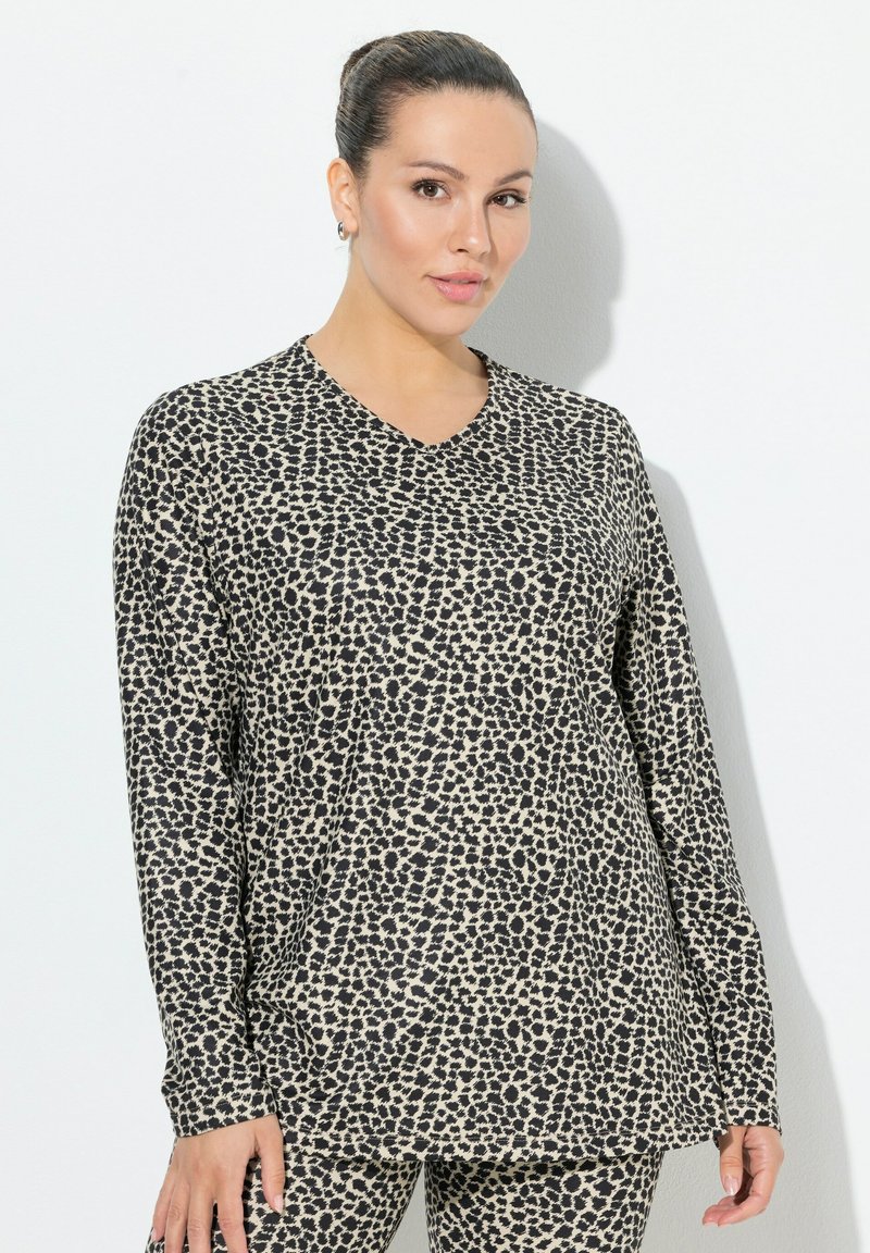 Langärmliges Oberteil in Beige mit schwarzem Leopardenmuster, das ein V-Ausschnitt-Design aufweist. Der Stoff hat eine glatte Textur und eine lockere Passform.
