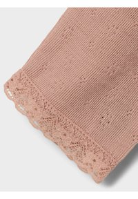 Stickad plagg i mjukt rosa med ett strukturerat mönster och en dekorativ spetskant vid fållen, som visar upp intrikata blommiga utskärningar.