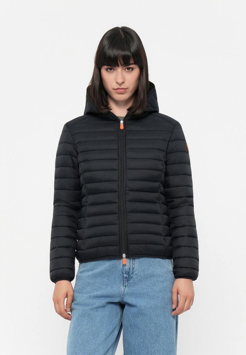 Zwarte gewatteerde jas met capuchon, gestikt ontwerp, vooraan met een rits en een oranje ritslip. Beschikt over elastische mouwen en een slim fit.